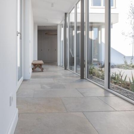 Gefliester Flur mit weißen Wänden und einer Terrasse rechtsseitig