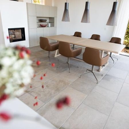 Langer Tisch mit 6 Stühlen hinter der Anrichte der Küche auf gefliestem Boden