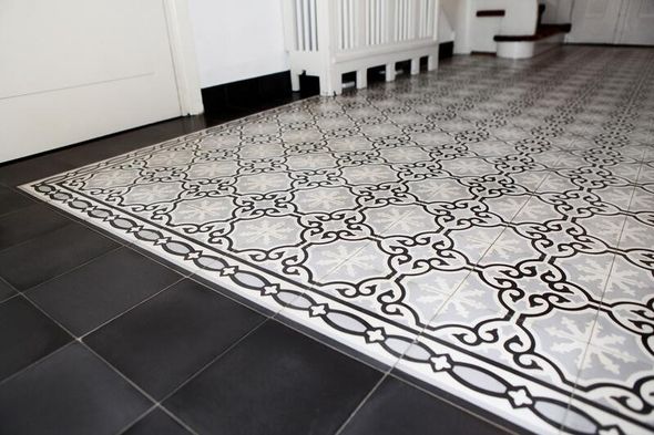 Edel gemusterte Bodenfliesen in schwarz, grau und Weißtönen umrahmt von schwarzen Fliesen